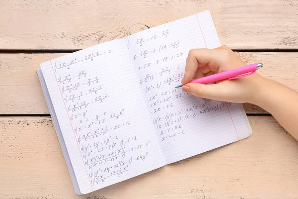 Frau Schreibt Mathematik Formeln Textbuch Mit Stift Auf Beigem Holzgrund — Stockfoto