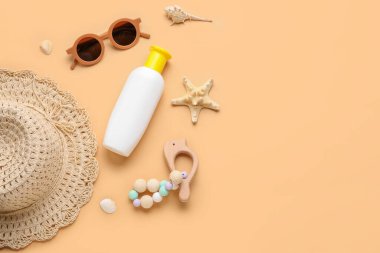 Bej arka planda plaj aksesuarları olan bebek için güneş kremi