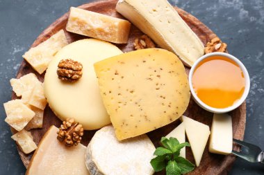 Farklı tipte peynir ve bal içeren tabaklar mavi arka planda