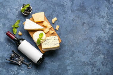 Farklı çeşitlerde lezzetli peynir ve şarap ile mavi arka planda.