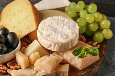 Tabakta farklı lezzetli peynirler var. Masada, yakın plan.