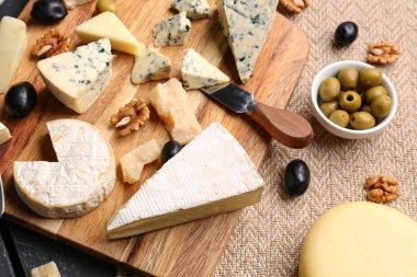 Masada farklı çeşit lezzetli peynirli ahşap tahta.