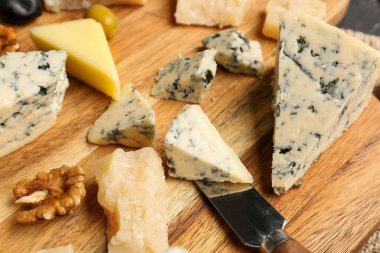 Masada farklı çeşit lezzetli peynirli ahşap tahta, yakın plan.