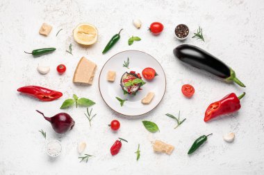 Lezzetli fırında patlıcan, parmesan ve hafif arka planda malzemelerle dolu bir tabak.