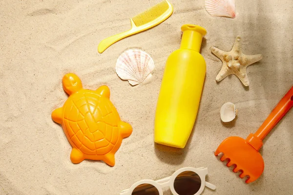 砂の上にビーチアクセサリーや貝殻と赤ちゃんのための日焼け止めクリーム — ストック写真