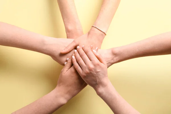 Mensen Die Handen Bij Elkaar Leggen Gele Achtergrond Bovenaanzicht Vriendschapsconcept — Stockfoto