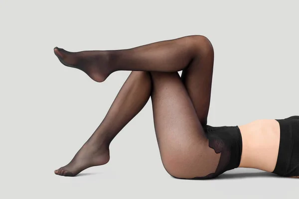 脚の美しいです女性で黒タイトオンライト背景 — ストック写真
