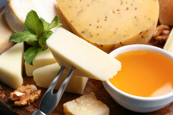 不同类型的奶酪和蜂蜜放在桌上 — 图库照片