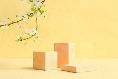 Dekoratif podyumlar ve bej arka planda çiçek açan şubeler