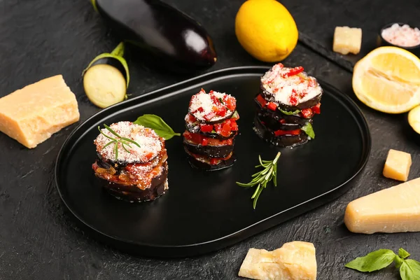 Tray with tasty baked Eggplant Parmesan on dark background
