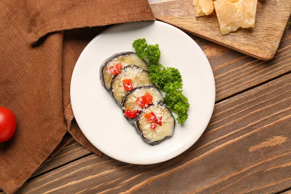 stock image Plate with tasty baked Eggplant Parmesan on wooden background