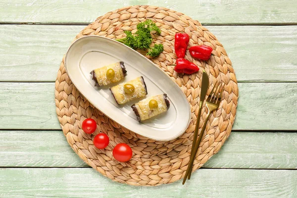 Plate with tasty baked Eggplant Parmesan on light wooden background