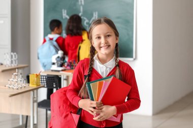 Fen dersinde defterleri olan küçük bir kız.