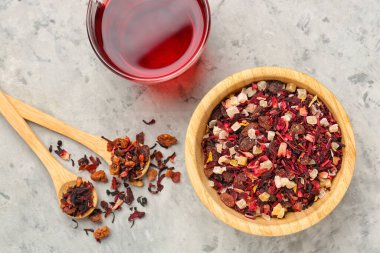 Gri grunge masasında kurutulmuş meyve çayı ile kase ve kaşıklar.