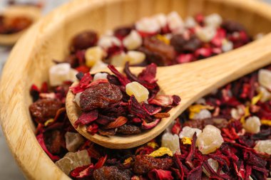 Gri grunge masasında kurutulmuş meyve çaylı kase ve kaşıklar, yakın plan.