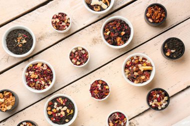 Beyaz ahşap arka planda farklı çeşit kurutulmuş meyve çayı çeşitleri.