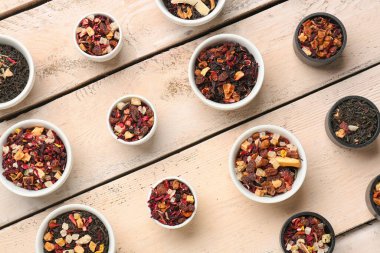 Beyaz ahşap arka planda farklı çeşit kurutulmuş meyve çayı çeşitleri.