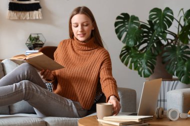 Evde çay fincanı okuyan kız öğrenci.