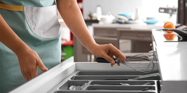 台所の引き出しにきれいな泡立て器を入れて女性 — ストック写真