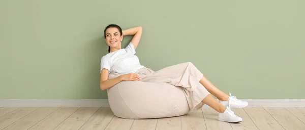Young Woman Relaxing Beanbag Chair Green Wall — Stock Photo, Image