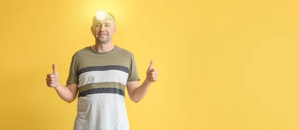 Gelukkig Volwassen Man Met Koplamp Zaklamp Tonen Duimen Gele Achtergrond — Stockfoto