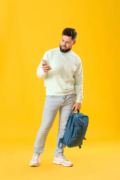Young Bearded Man Backpack Using Mobile Phone Yellow Background — Stock Photo, Image