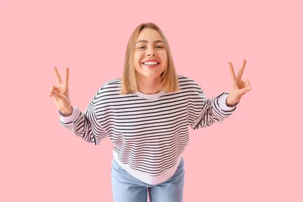 Junge Frau Gestreiftem Sweatshirt Zeigt Siegesgeste Auf Rosa Hintergrund — Stockfoto