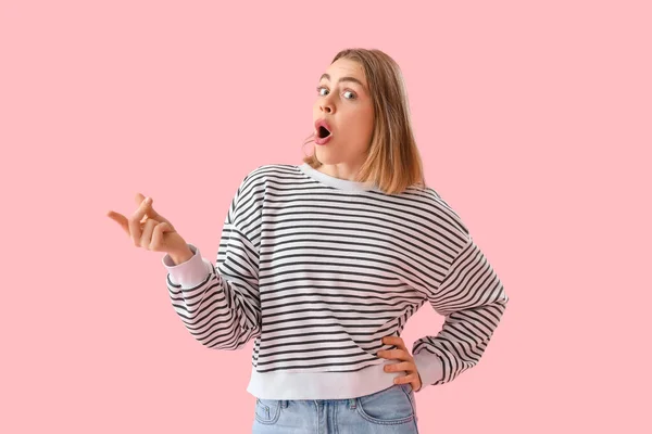 Çizgili Tişörtlü Genç Bir Kadın Pembe Arka Planda Parmaklarını Şaklatıyor — Stok fotoğraf