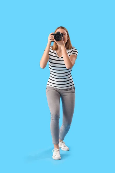 青の背景にプロのカメラを持つ女性写真家 — ストック写真