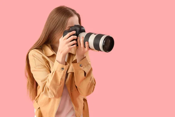 持有粉色背景专业相机的年轻女性摄影师 — 图库照片