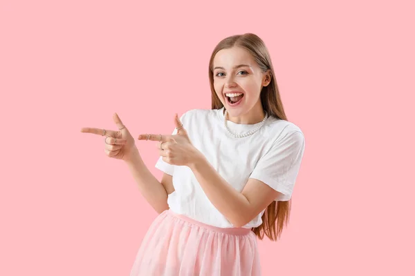 Szczęśliwa Młoda Kobieta Shirt Wskazując Coś Różowym Tle — Zdjęcie stockowe