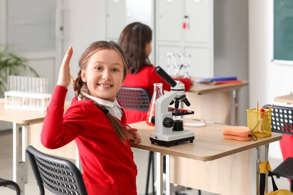理科教室で化学の授業を受けている顕微鏡を持つ女の子 — ストック写真