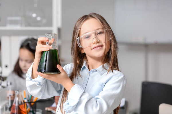 Little girl with conical flask in science classroom