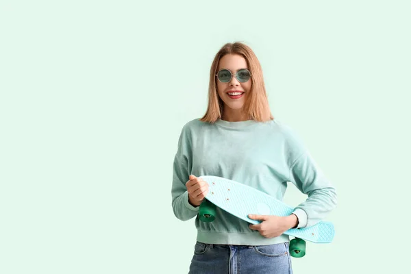Mujer Joven Gafas Sol Con Monopatín Sobre Fondo Verde — Foto de Stock
