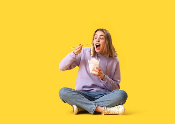 Junge Frau Isst Chinesische Nudeln Auf Gelbem Hintergrund — Stockfoto