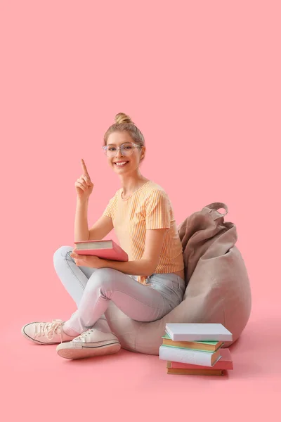 Junge Frau Mit Büchern Die Auf Etwas Auf Rosa Hintergrund — Stockfoto