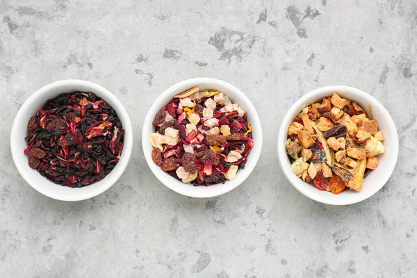 stock image Bowls with different dried fruit tea on grey grunge table