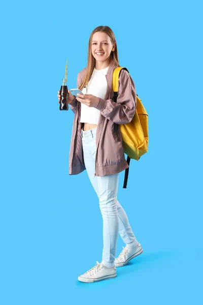 Female Student Bottle Cola Using Mobile Phone Blue Background — Stock Photo, Image