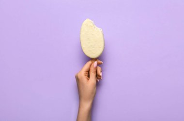 Lezzetli çikolata kaplı dondurmayı leylak arka planda tutan kadın.