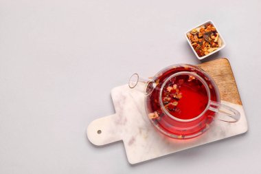 Çaydanlık ve gri arka planda bir kase kurutulmuş meyve.