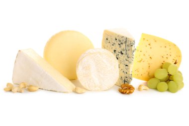 Beyaz arka planda izole edilmiş üzüm ve fındıklı farklı peynir türleri.