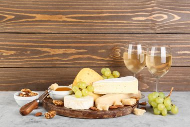 Farklı peynir türleri, şarap ve üzümlü bardaklar.