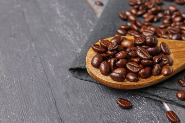 Koyu ahşap arka planda kahve çekirdekli kaşık.