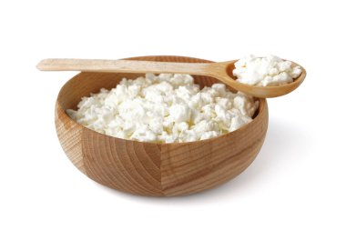 Beyaz arka planda lezzetli süzme peynirli kase ve kaşık.