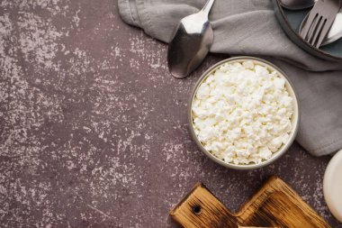 Koyu grunge arka planda lezzetli süzme peynirli kase