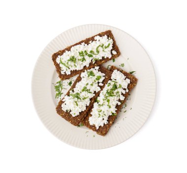 Beyaz arka planda lezzetli süzme peynir ve çavdar ekmeği tabağı.