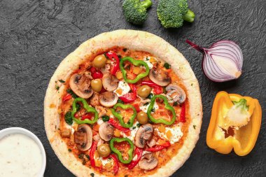 Sebzeli pizza, koyu arkaplanda malzemeler var.