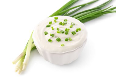 Bowl of tasty sour cream with green onion on white background clipart