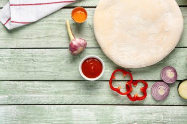 Yeşil ahşap arka planda sebze turtası hazırlamak için ham hamur ve malzemeler