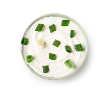 Beyaz arka planda yeşil soğanlı bir kase lezzetli ekşi krema